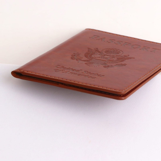 A brown PU leather passport holder with an embossed design and a branding logo.