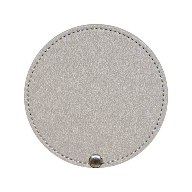 A round makeup mirror in a soft beige colour, featuring a textured finish and a metal clasp at the bottom.