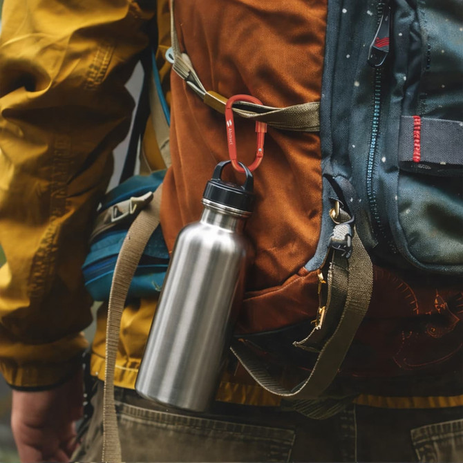 A stainless steel drink bottle is attached to a backpack with a red custom D shape camping carabiner.