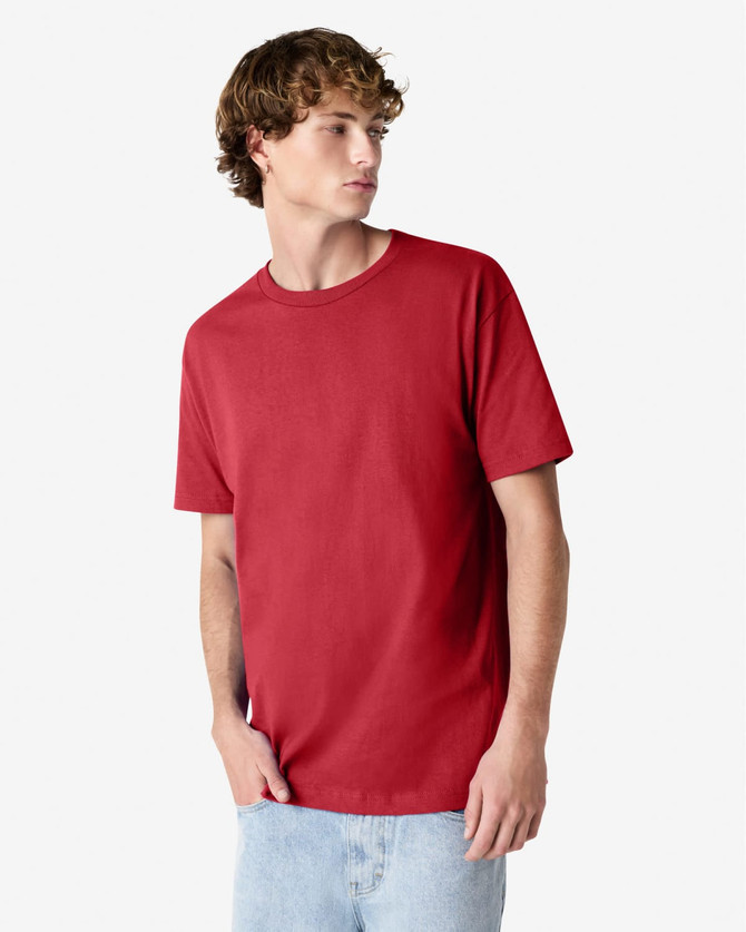 A red heavyweight cotton unisex T-shirt on a model wearing light blue jeans, with a logo on the shirt.
