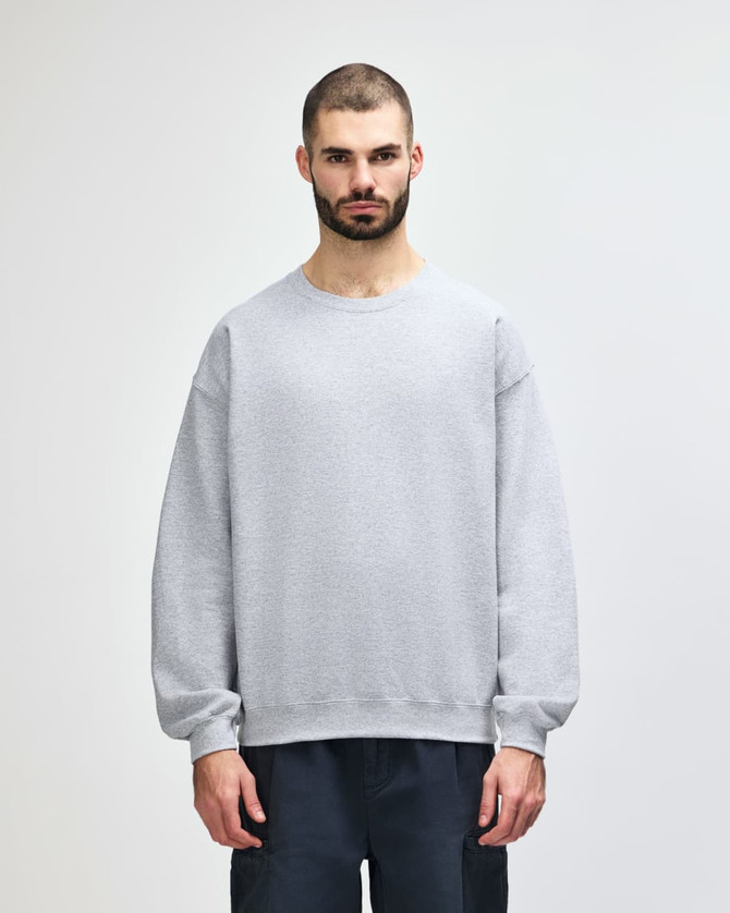 A grey Gildan Heavy Blend adult crewneck sweatshirt with long sleeves and a logo.