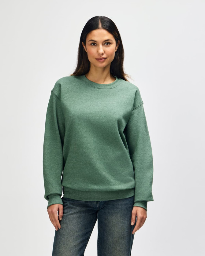 A green Gildan Heavy Blend adult crewneck sweatshirt displayed on a model, featuring long sleeves and a casual fit.
