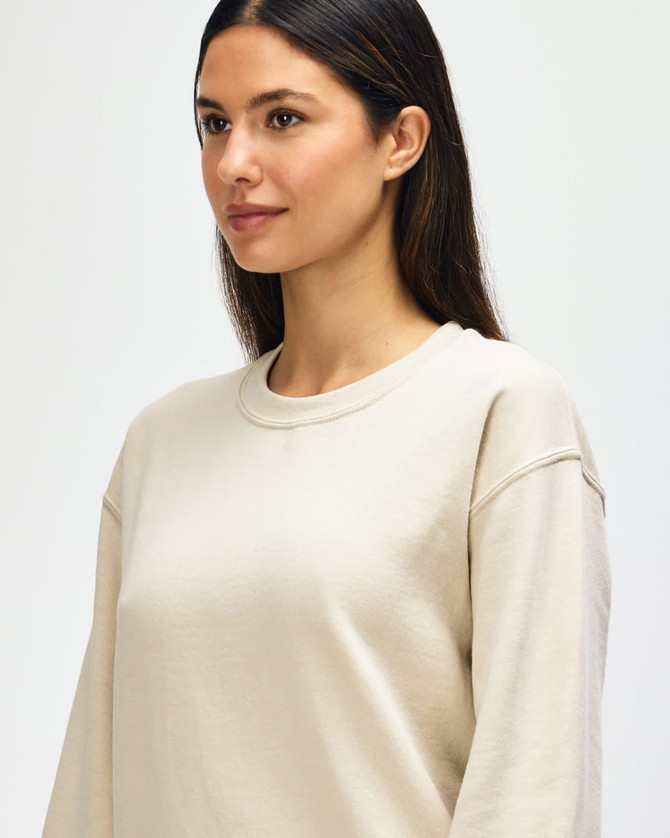 A light beige Gildan Heavy Blend adult crewneck sweatshirt with a relaxed fit and a logo.