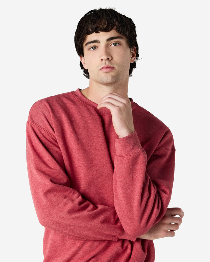 A crewneck sweatshirt in a rich red colour, featuring long sleeves and a relaxed fit. It has a logo on it.