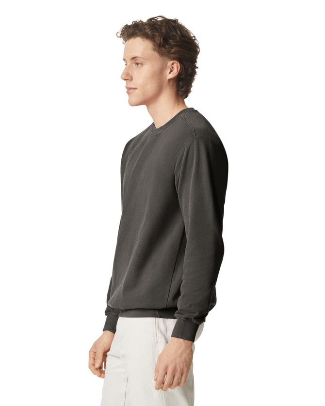 A grey adult crewneck sweatshirt displayed on a model from the side, featuring a simple design and a logo.