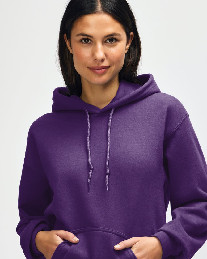 A purple hooded sweatshirt is being worn by a young man, who is pulling the hood over his head.