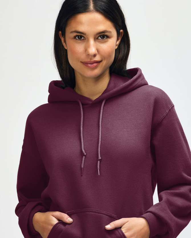 A hooded sweatshirt in a deep burgundy colour, featuring a drawstring hood and an individual adjusting the neckline.