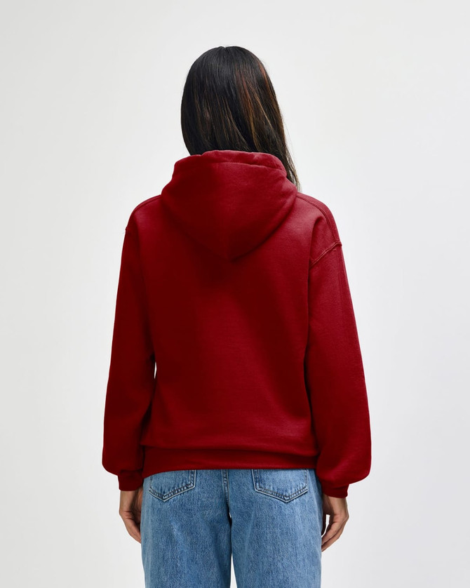 A red hooded sweatshirt displayed from the back, featuring a large hood and a relaxed fit. The image includes a branding logo.
