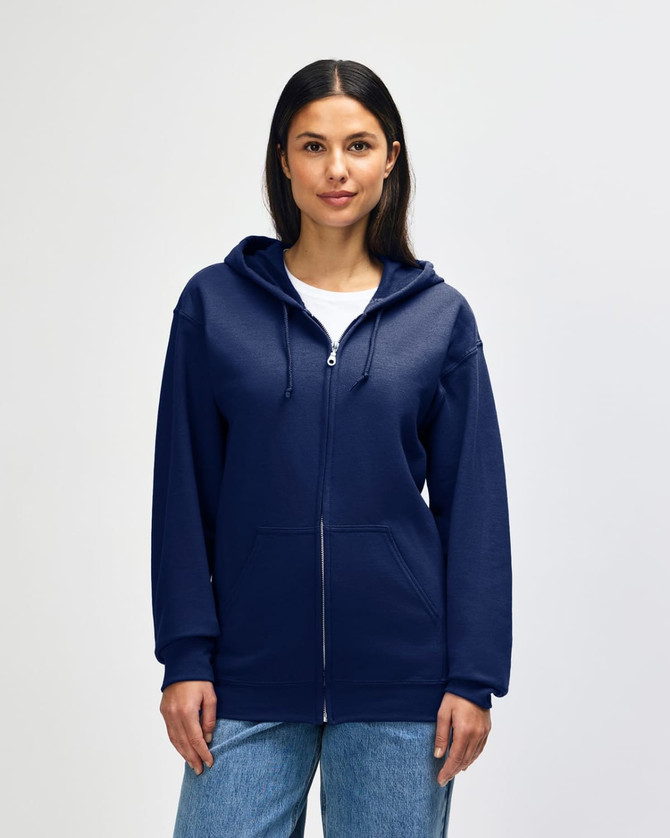 A navy blue Gildan Heavy Blend adult full zip hooded sweatshirt on a model adjusting the hood. The sweatshirt has a logo.