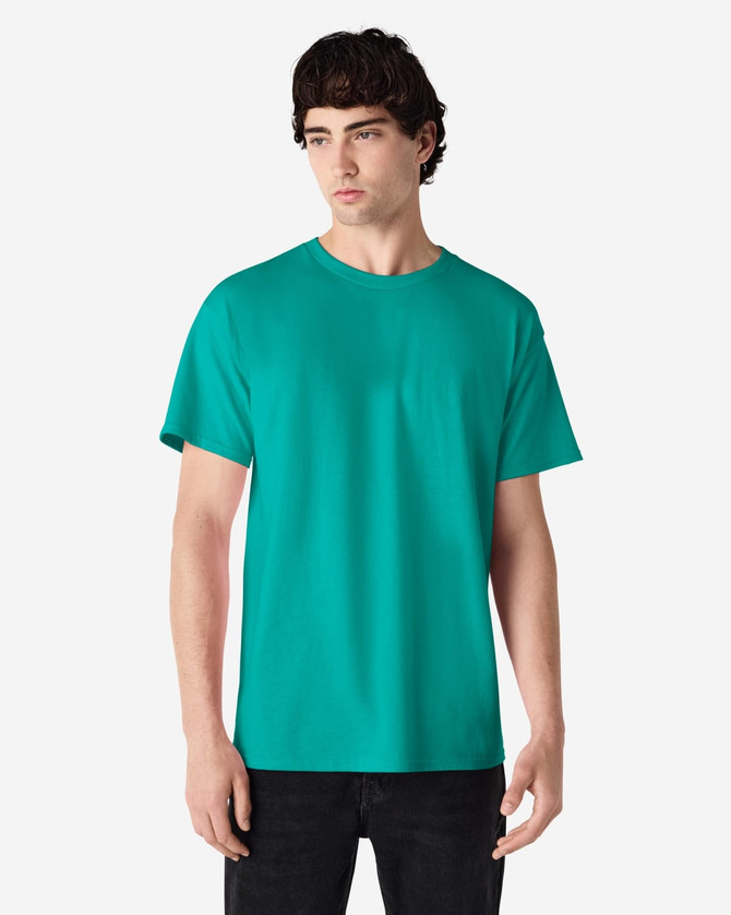 A teal Gildan Ultra Cotton adult t-shirt is displayed on a model standing against a plain background.