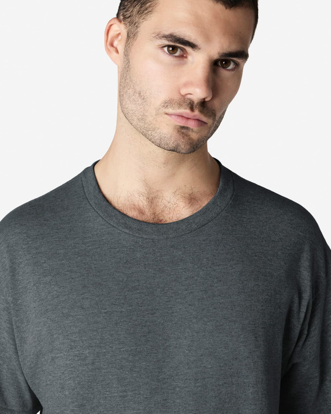 A grey Gildan Ultra Cotton adult t-shirt displayed on a male model, featuring a round neckline and long sleeves.