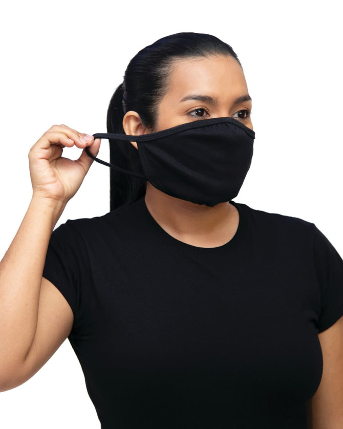 A woman wearing a black non-medical mask, holding the ear strap with one hand. The mask is simple and plain.