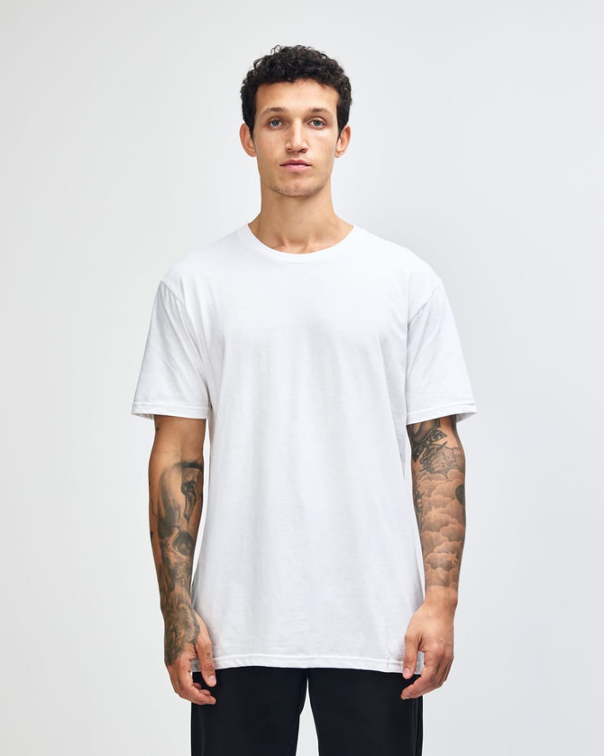 A woman wearing a plain white unisex short sleeve t-shirt. The t-shirt has a logo on it.