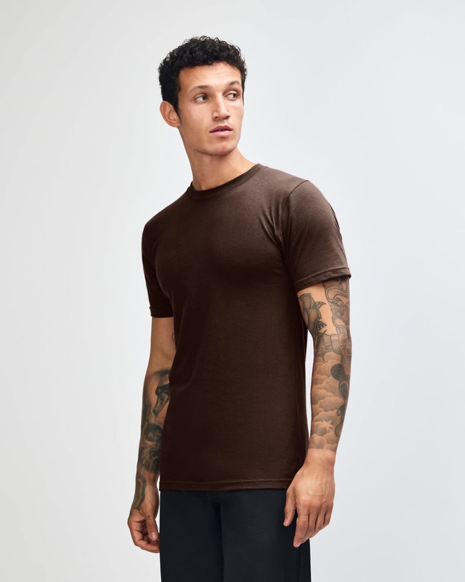A brown unisex fine jersey short sleeve T-shirt displayed on a model from the side. Features a logo.