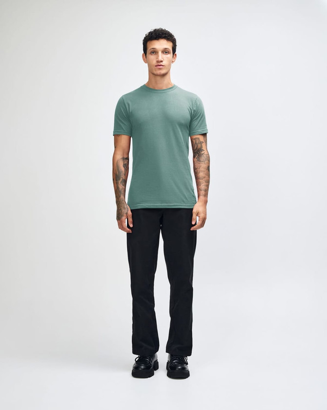 A unisex fine jersey short sleeve t-shirt in teal, paired with beige cargo pants, worn by a model.