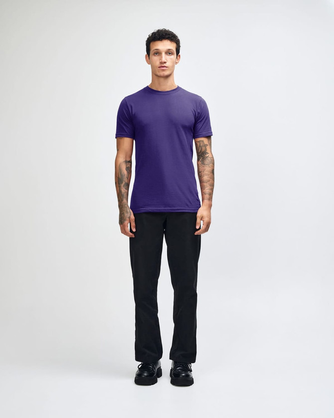 A unisex fine jersey short sleeve T-shirt in purple, worn with beige cargo pants, featuring a logo.