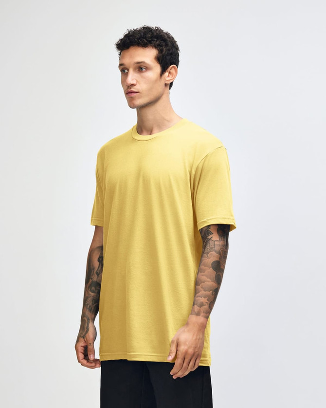 A yellow unisex short sleeve t-shirt displayed on a model from the side, featuring a simple design and a logo.