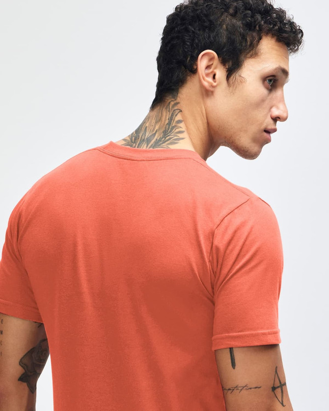 A back view of a man wearing an orange American Apparel fine jersey short sleeve t-shirt, featuring a tattoo.