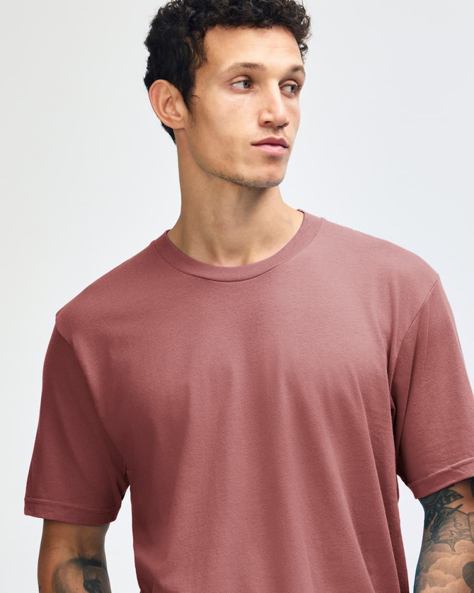 A unisex fine jersey short sleeve T-shirt in a muted red colour, paired with light blue oversized pants.