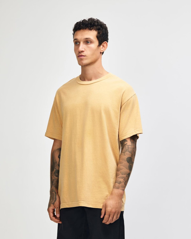 A unisex heavyweight cotton t-shirt in a mustard yellow shade, featuring a relaxed fit and short sleeves.