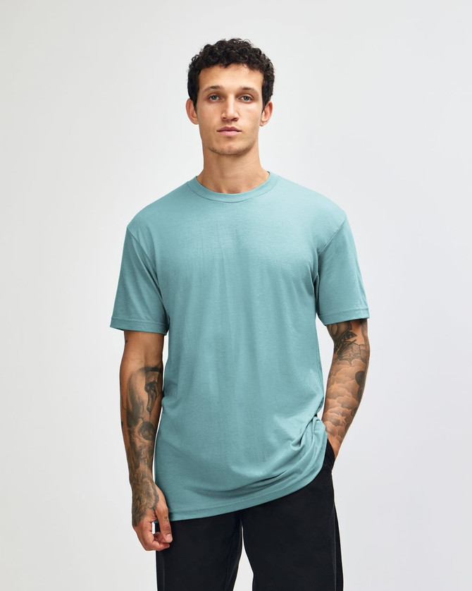 A unisex CVC short sleeve T-shirt in teal, featuring a simple design and a logo on the front.