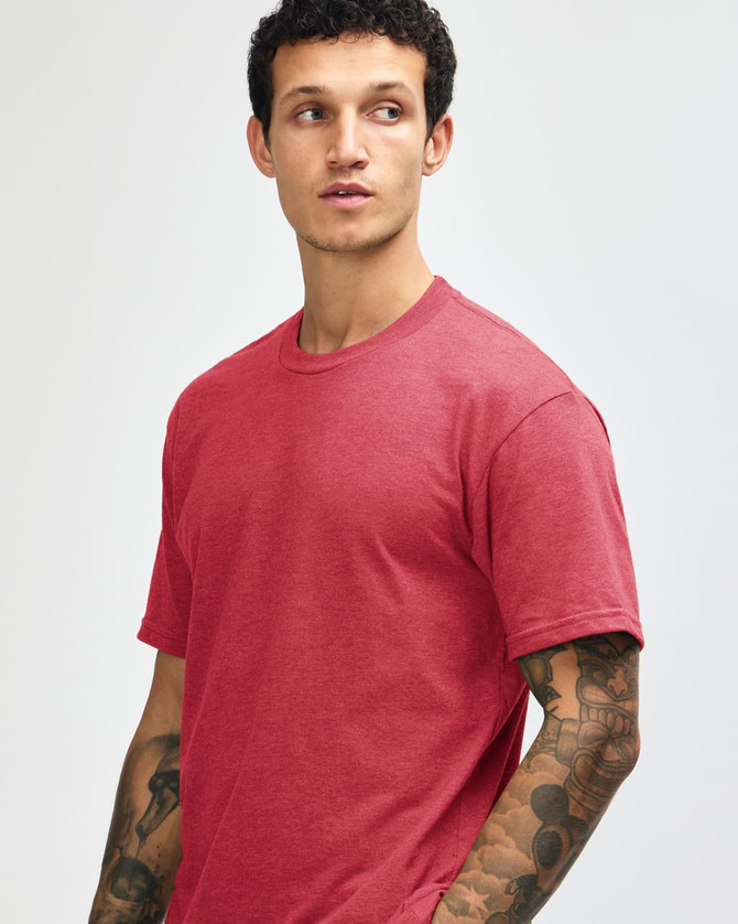 A unisex short sleeve T-shirt in a warm red colour, displayed on a model with a simple design and logo.