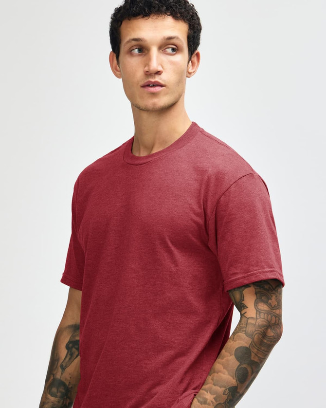 A unisex CVC short sleeve t-shirt in a deep red colour, displayed on a model with a neutral background.