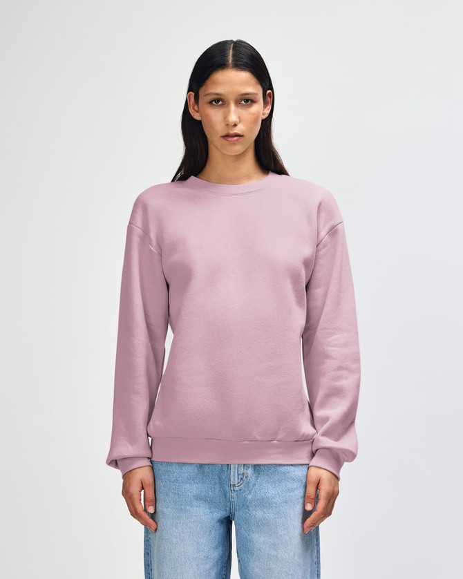 A unisex crewneck sweatshirt in a soft lilac colour, featuring long sleeves and a relaxed fit. It has a small logo.