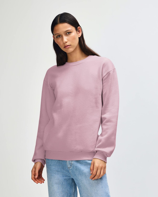 A unisex crewneck sweatshirt in light pink, featuring a relaxed fit and long sleeves. It has a logo on the front.