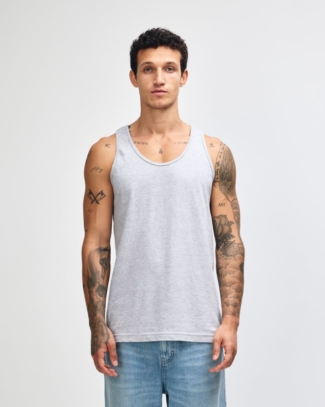 A light grey unisex fine jersey tank top is displayed on a model, featuring a simple design and a relaxed fit.