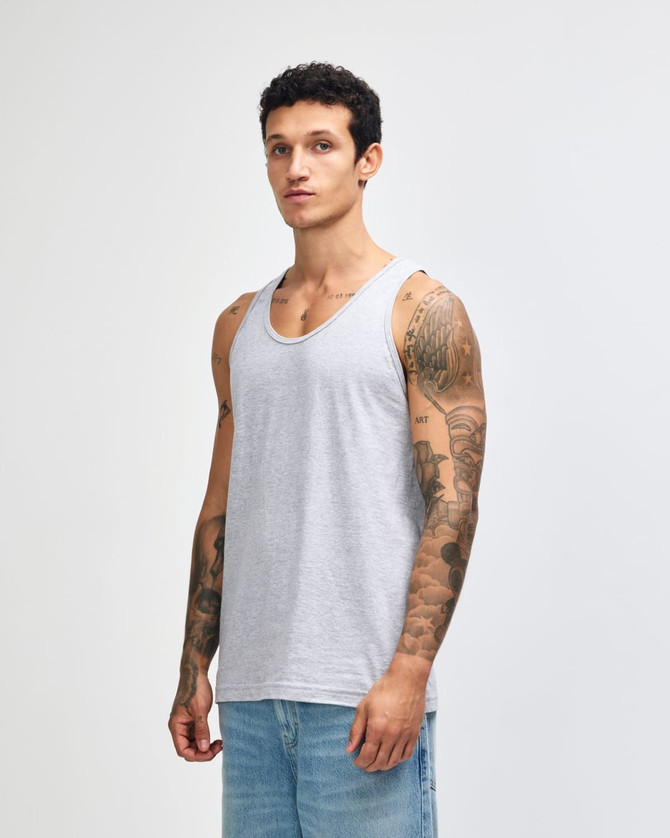 A unisex fine jersey tank in grey, featuring a logo, displayed by a model wearing casual jeans.