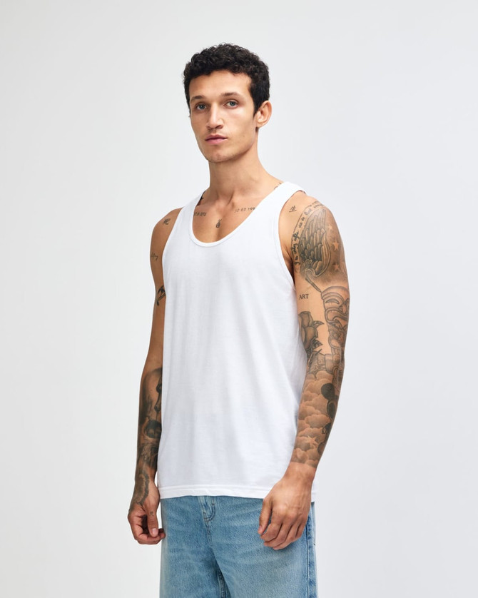 A plain white unisex fine jersey tank top displayed on a model, featuring a simple design and no visible logos.