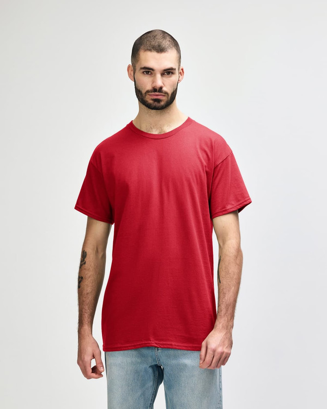 A red Gildan Heavy Cotton adult t-shirt displayed on a model. The shirt has a logo branding.