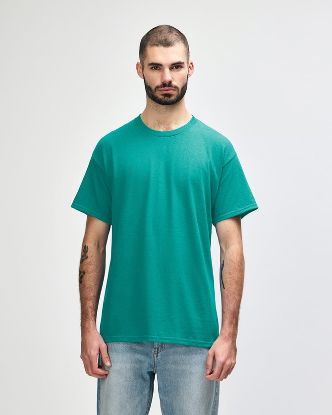 A turquoise Gildan Heavy Cotton adult T-shirt displayed on a model, featuring a round neck and short sleeves.