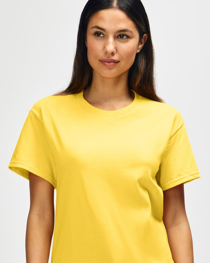 A yellow Gildan Heavy Cotton Adult T-Shirt displayed on a model, featuring a logo.