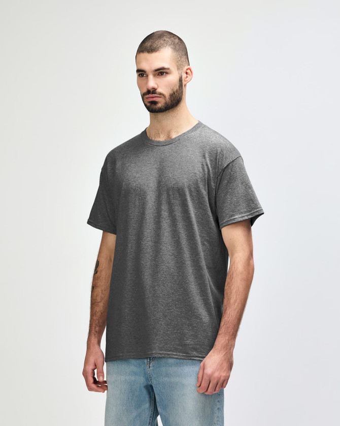 A grey Gildan Heavy Cotton adult t-shirt displayed on a model, featuring a simple design and a logo.