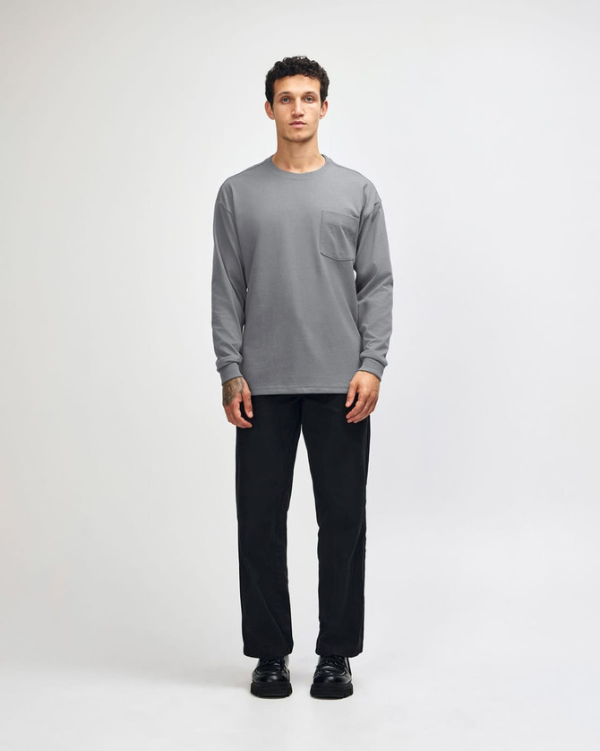 A model wears a grey long-sleeve t-shirt paired with khaki cargo pants and sneakers.