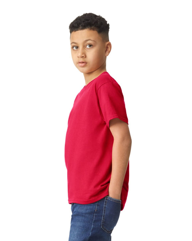 A boy wearing a red Gildan Heavy Cotton Youth T-Shirt, featuring a simple design and casual fit.