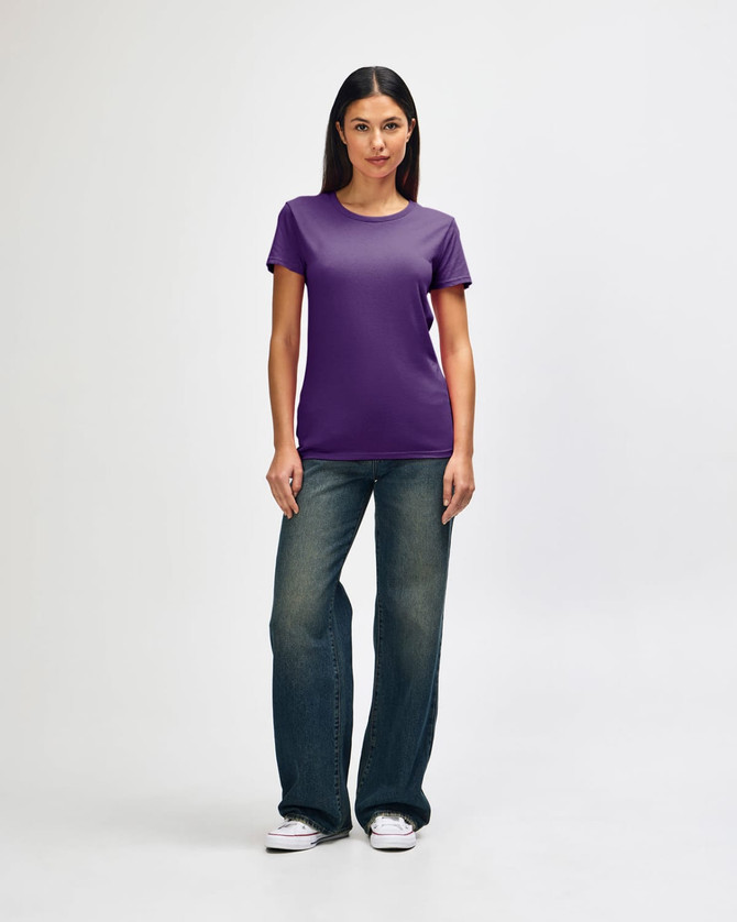 A purple Gildan Heavy Cotton Ladies' T-Shirt displayed on a model paired with blue jeans and white sneakers.
