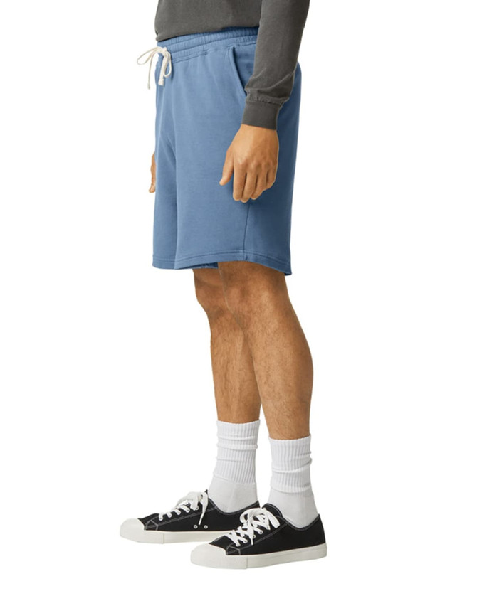 Lightweight sweatshorts in blue, featuring an elastic waistband and drawstring, styled with black sneakers and white socks.