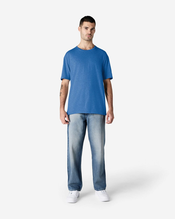 A model wearing a blue Gildan Softstyle adult T-shirt paired with light blue jeans and white shoes.