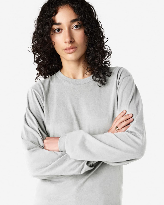 A long sleeve t-shirt in light grey, featuring a round neckline and an understated design, with a logo present.