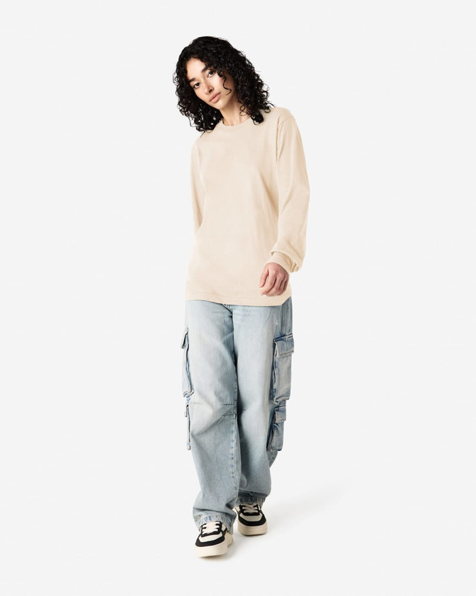 A beige long sleeve t-shirt paired with light blue cargo pants, featuring a logo on the shirt.