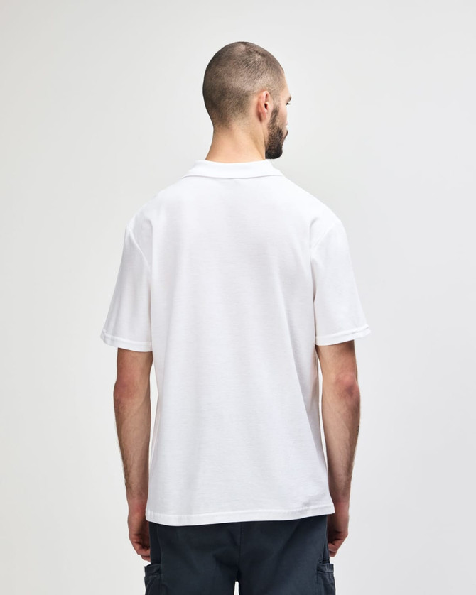 A white Gildan Softstyle adult double pique polo shirt displayed on a model from the back, featuring a small logo.