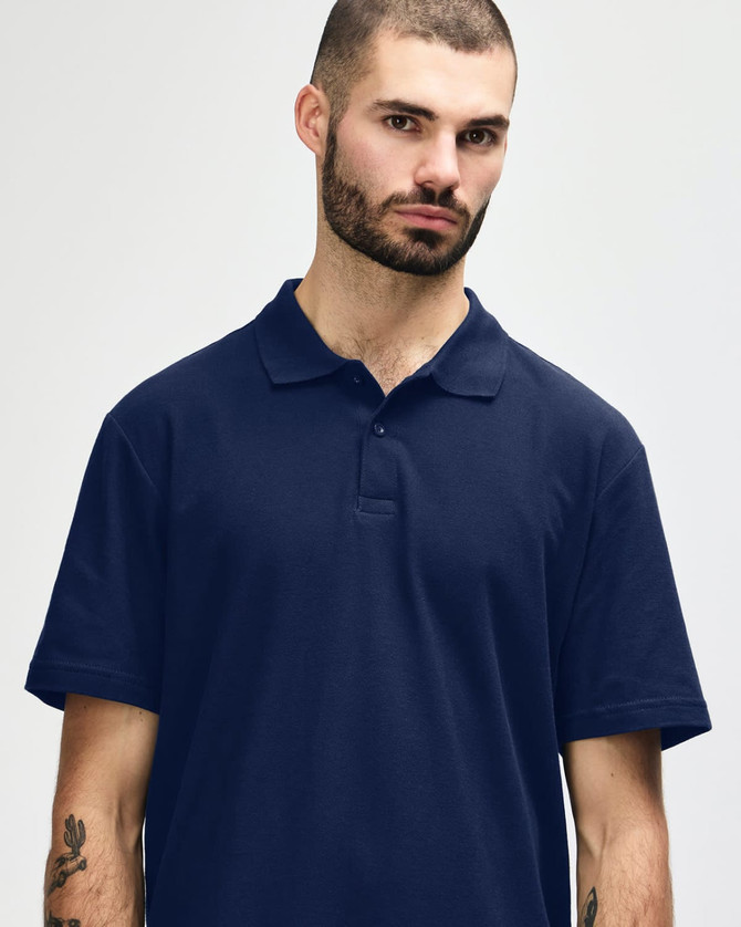 A man wearing a navy blue Gildan Softstyle Adult Double Pique Polo with a collar and buttons.
