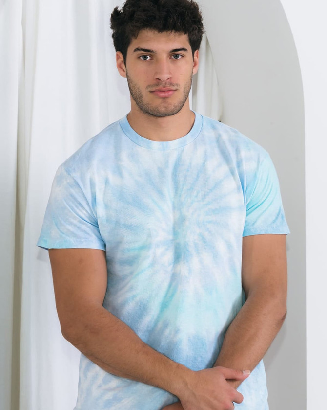 A tie-dye adult t-shirt in light blue hues, featuring a circular pattern. The shirt has a logo on it.