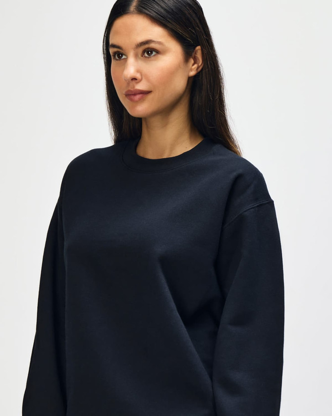 A black Gildan Softstyle adult sweatshirt displayed on a model, featuring a simple design and round neckline.