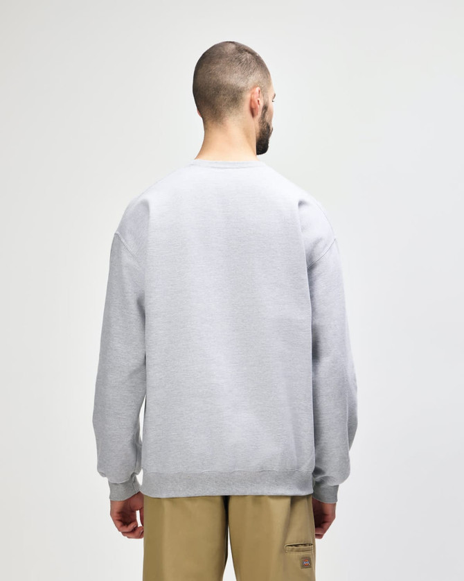 A grey Gildan Softstyle adult sweatshirt viewed from the back, worn with dark jeans. It features a logo.
