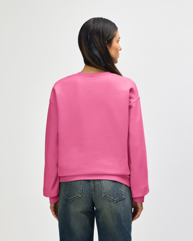 A pink Gildan Softstyle adult sweatshirt seen from the back, paired with blue jeans. The sweatshirt has a logo.