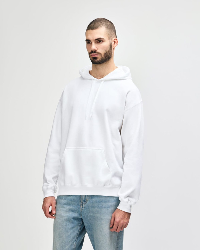A white hooded sweatshirt with a relaxed fit, featuring a front pocket and a hood. The model is smiling and wearing denim jeans.